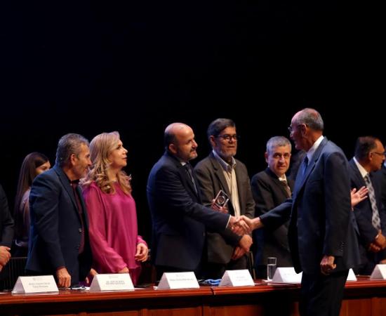 Autoridades universitarias entregando galardón a trabajador UdeG