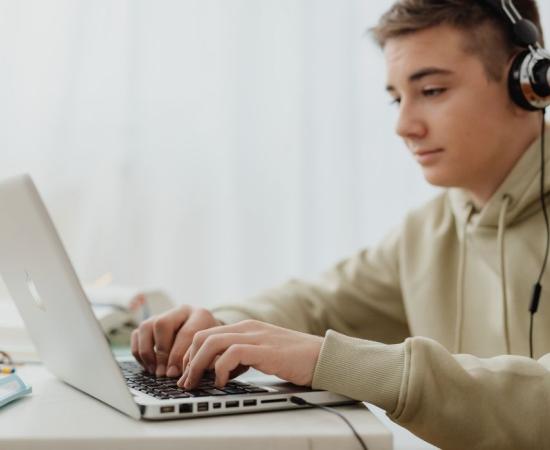 Joven escribiendo en laptop